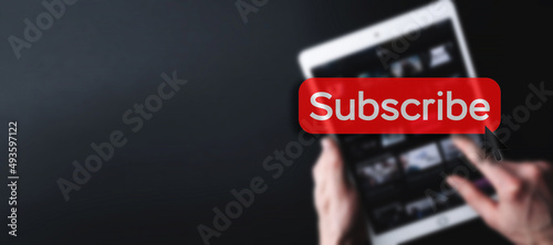Subscription service. Online video red subscribe button. Internet service on laptop digital tablet blured banner background. Streaming video. Communication network.
