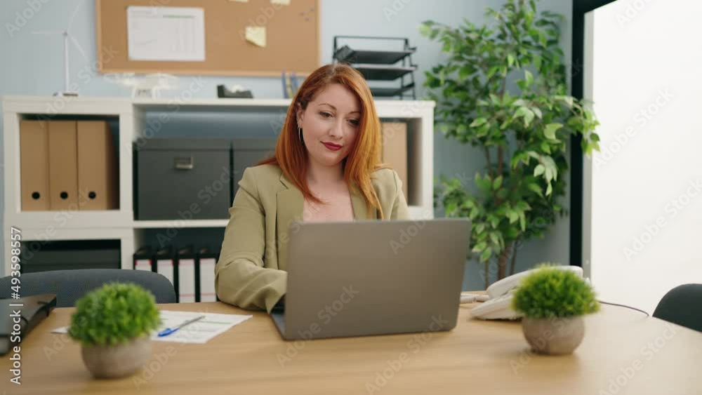 Young redhead woman business worker using laptop working at office Young redhead woman business worker using laptop working at office