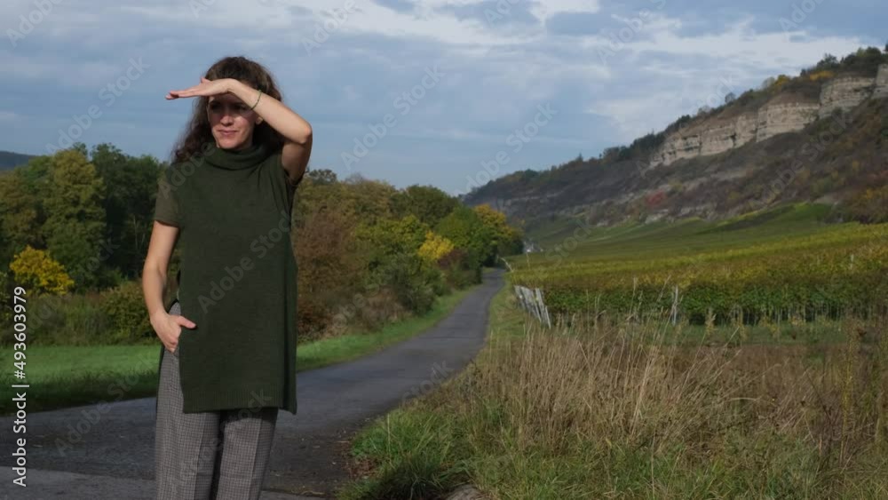Portrait of a beautiful, stylish hipster woman enjoying nature, looking around and pointing somewhere. Outdoor adventures, autumn landscape, fresh air, relax and recreation of modern people. 4K Portrait of a beautiful, stylish hipster woman enjoying nature, looking around and pointing somewhere. Outdoor adventures, autumn landscape, fresh air, relax and recreation of modern people. 4K