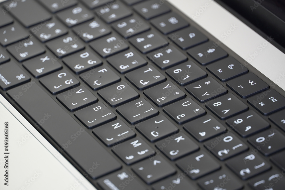 Close up of laptop keyboard with two languages Arabic and English, arabic letters Close up of laptop keyboard with two languages Arabic and English, arabic letters