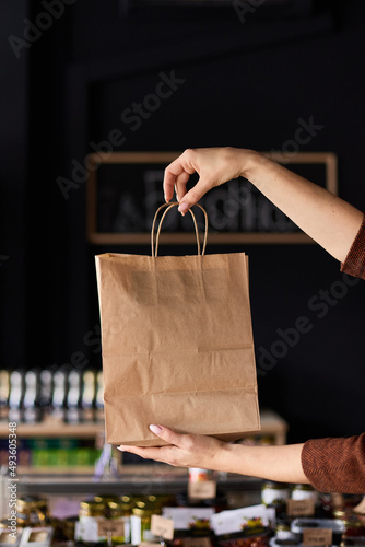 The girl holds a paper bag in her hands