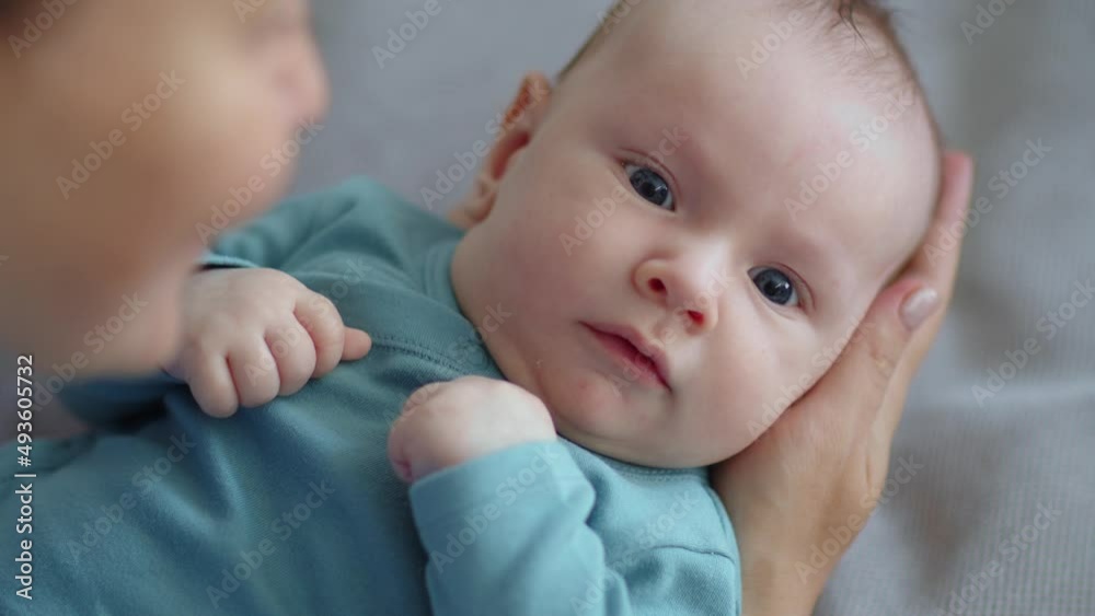 Mom playing with a newborn baby - slow motion. Child is trying to pronounce sounds while looking at his mom. The face of an active caucasian infant looking at a parent. Happy male kid is looking. Mom playing with a newborn baby - slow motion. Child is trying to pronounce sounds while looking at his mom. The face of an active caucasian infant looking at a parent. Happy male kid is looking.
