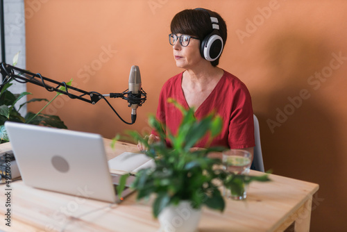 Wallpaper Mural Mature woman making podcast recording for her online show. Attractive business woman using headphones front of microphone for a radio broadcast Torontodigital.ca