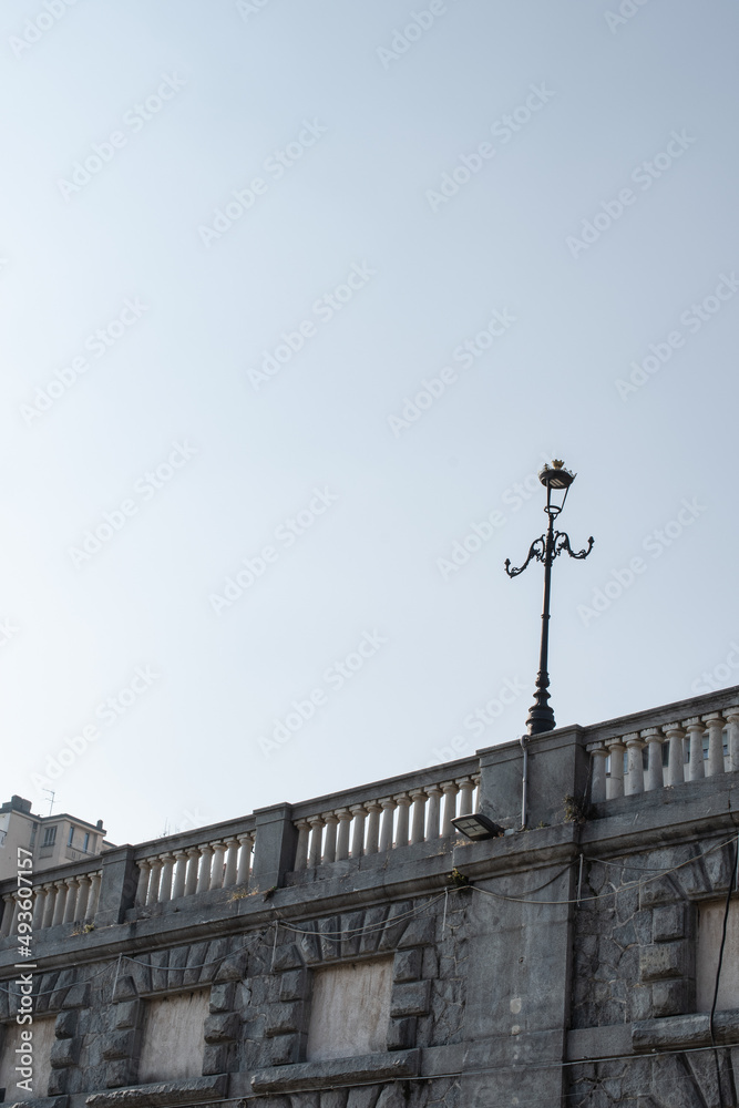 Ancient architecture, a lantern, old lamp on a stone bridge in Turin, Piemonte, Italy. Behind a clear sky. Ancient architecture, a lantern, old lamp on a stone bridge in Turin, Piemonte, Italy. Behind a clear sky.