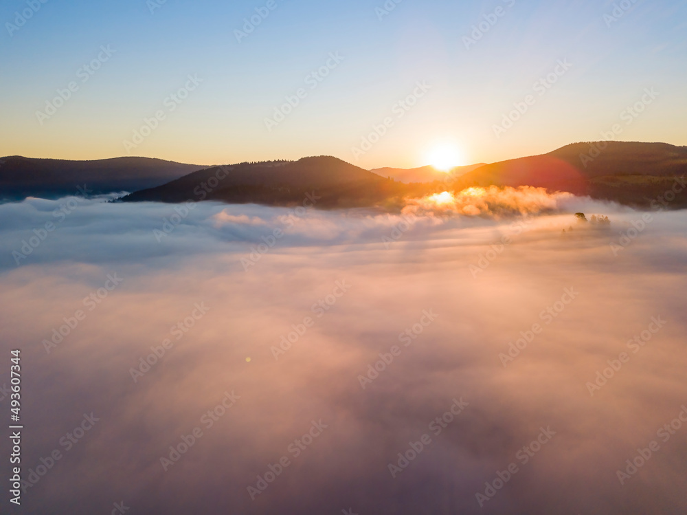 Sunrise over the fog in the Ukrainian Carpathians. Aerial drone view.