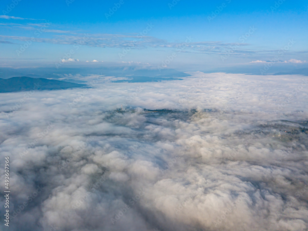 Fototapeta premium High flight above the clouds in the mountains. Aerial drone view.
