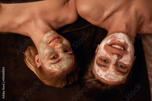 Woman with clay mask and man with cream on faces