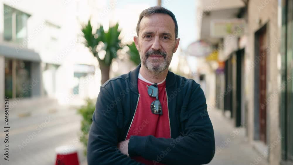 Middle age man smiling confident standing with arms crossed gesture at street Middle age man smiling confident standing with arms crossed gesture at street