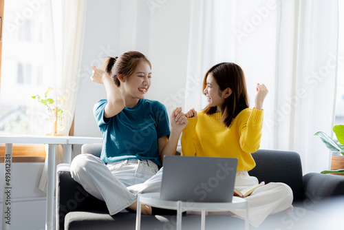 The two women were in the living room, they were delighted after looking at the information on their laptops, they spent their vacations watching movies and listening to music together.