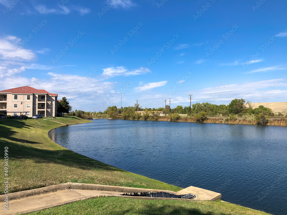 Retention pond in apartment neighborhood with concrete drainage pipe in Lewisville, Texas, America