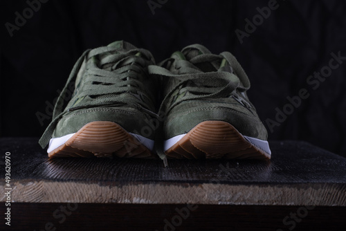 Sports stylish leather sneakers on a dark background in a low key.