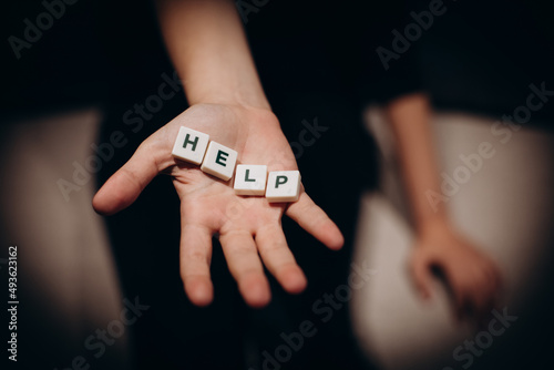 Girl asking for help. Girl stretches out her hands with the word help in the palms