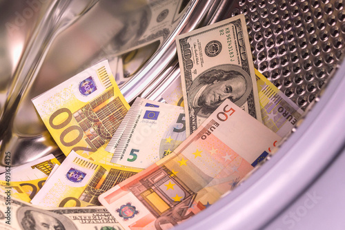 Money laundering. Money cleaning concept. Washing US dollars and euro