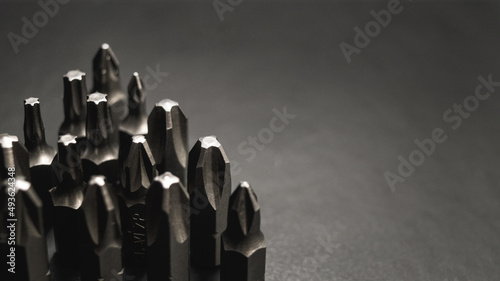 Metal nozzles on a screwdriver on a black background. Image with empty place for text. Background for web sites. Close-up.