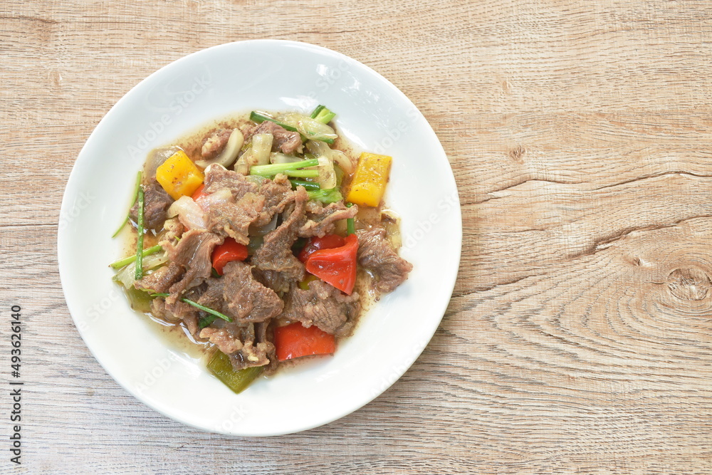 fried slice beef meat tendon with onion and bell pepper in oyster sauce on plate fried slice beef meat tendon with onion and bell pepper in oyster sauce on plate