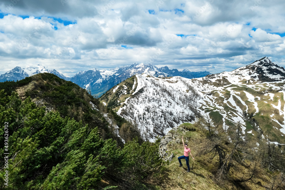 Hiker man breathing on the summit of Hahnkogel (Klek) with scenic view on mountain peaks in the Karawanks and Julian Alps, Carinthia, Austria. Border with Slovenia. Triglav National Park. Freedom