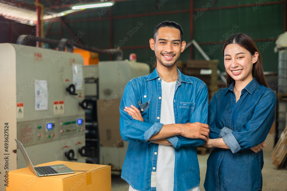 Obraz premium Couple asian entrepreneur work in stock or warehouse industrial, businessman and woman use laptop computer or tablet for check inventory and logistic management.