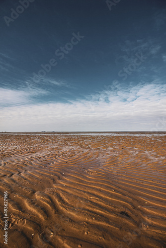 View on the Wadden sea on a sand beach and sky during low tide