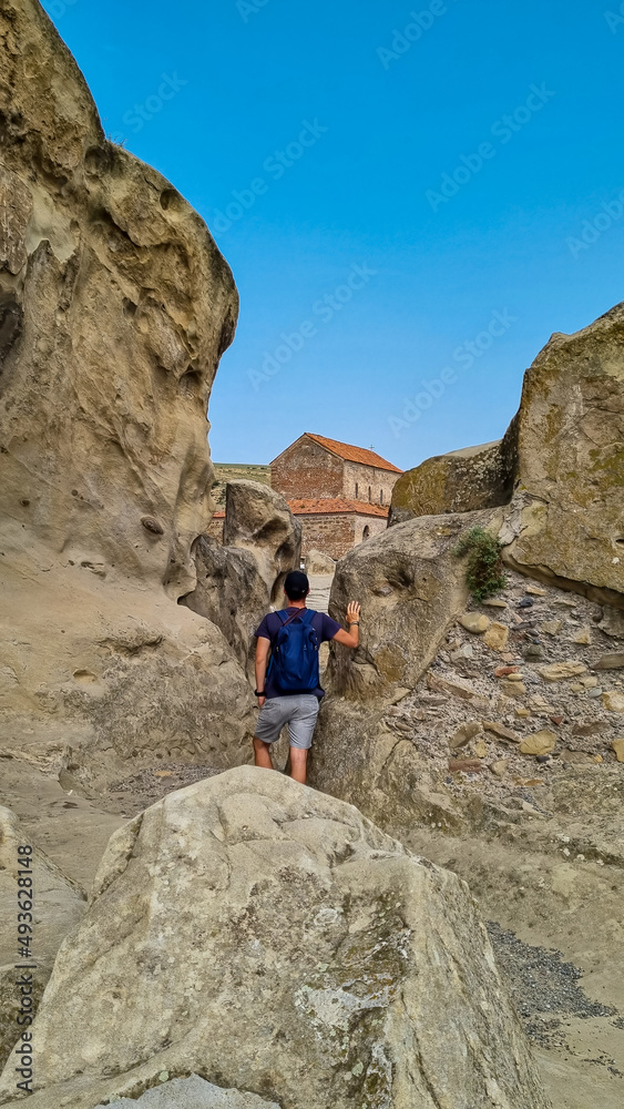 A male tourist exploring the ancient cave city of Uplistsikhe overlooking the Mtkvari river in the Shida Kartli Region of Georgia, Caucasus, Eastern Europe. Sightseeing, tourism, walking. Near Gori A male tourist exploring the ancient cave city of Uplistsikhe overlooking the Mtkvari river in the Shida Kartli Region of Georgia, Caucasus, Eastern Europe. Sightseeing, tourism, walking. Near Gori