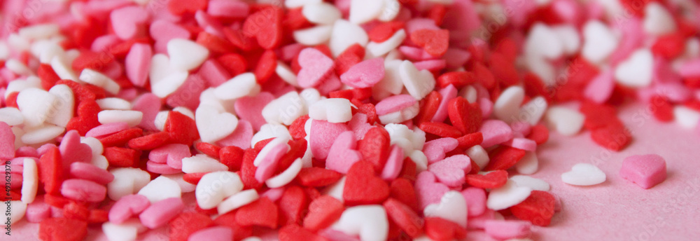 Multicolored background with candy hearts. Pink, white, red hearts. Love. Simovl love. Valentine is Day. Lots of small hearts. Flat. Copy space for text. Banner Multicolored background with candy hearts. Pink, white, red hearts. Love. Simovl love. Valentine is Day. Lots of small hearts. Flat. Copy space for text. Banner
