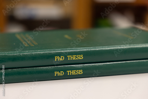 Canvastavla a pile of PhD theses of green cover, office or library background