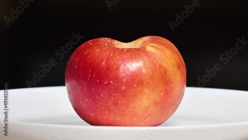 Half apple in plate, rotted from inside, the core is rotten but it looks delicious from outside, 4k footage.