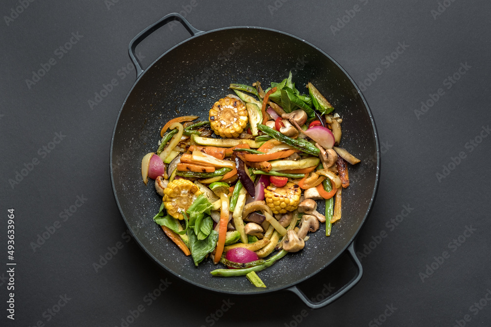 Wok pan with vegetables. Food photography, dark moody