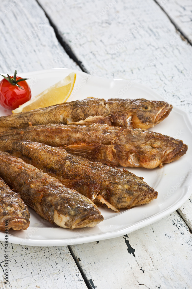 Fried fish goby, Ukrainian cooking. Photo of food on a dark background. Fried fish goby, Ukrainian cooking. Photo of food on a dark background.