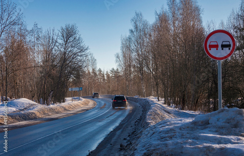 Foto Road sign overtaking is prohibited at the turn of snow-covered highway