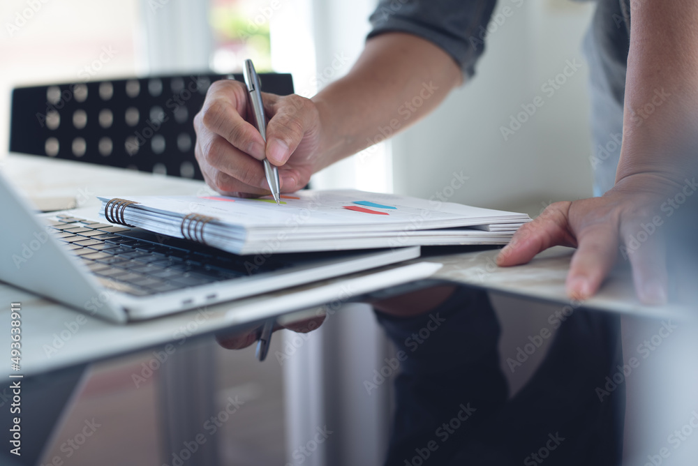 Close-up of businessman making agenda on personal organizer on desktop calendar and planner at workplace, event planning concept Close-up of businessman making agenda on personal organizer on desktop calendar and planner at workplace, event planning concept