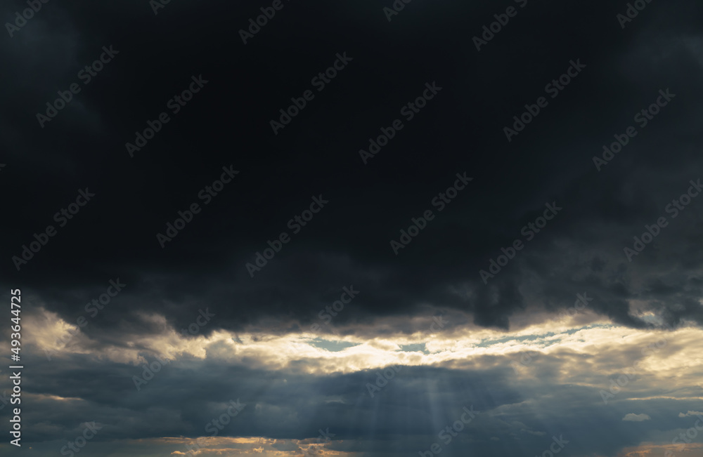 beautiful dramatic sky and sunlight, dark silhouette of clouds as background