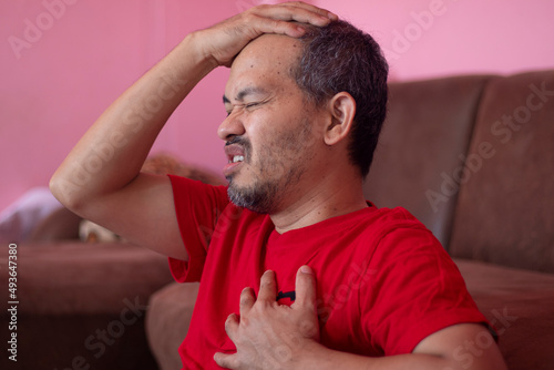 man holding his right hand left hand on chest cry in pain