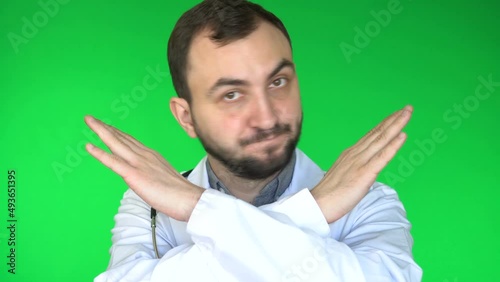 Medical doctor man looking at camera and said No by crossing his arms. Green screen background