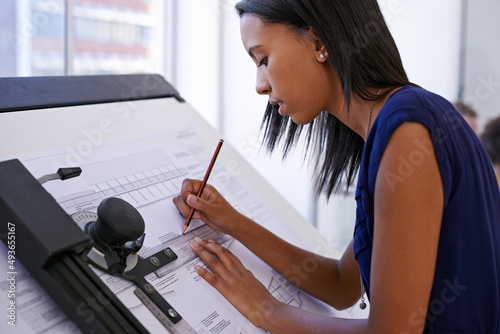 This is what she does best. Cropped shot of an attractive female architect working at a drawing board. photo