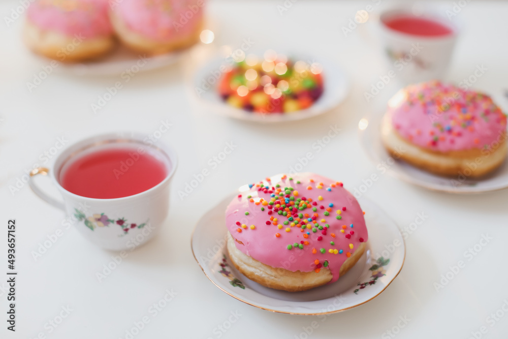 holiday, birthday party composition with colorful pink glazed donuts on white table, flatlay top view holiday, birthday party composition with colorful pink glazed donuts on white table, flatlay top view