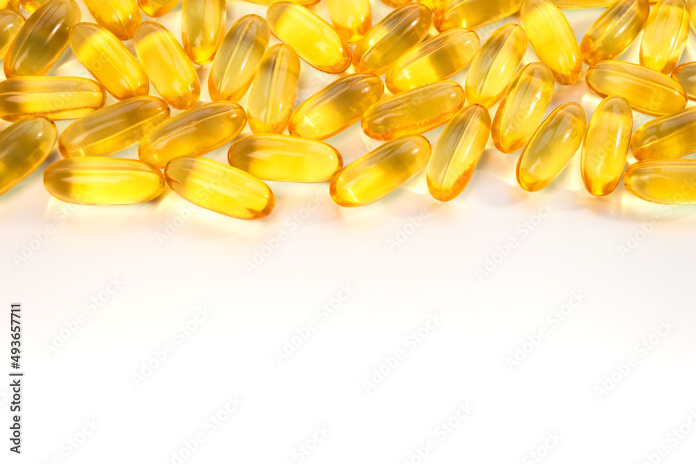 Yellow omega 3 capsules on the from above of a white background. Header, footer and running title for a website, banner, post or other promotional product. Close-up, top view, free space for text. Yellow omega 3 capsules on the from above of a white background. Header, footer and running title for a website, banner, post or other promotional product. Close-up, top view, free space for text.