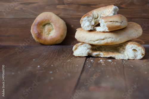 uzbek flatbread white bread is broken into pieces crumbs on a brown background illustration