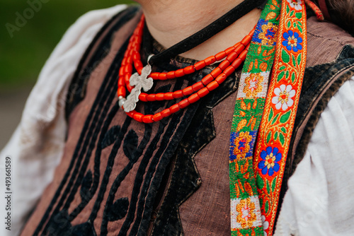 Elements of Ukrainian traditional national costume close-up: necklace, corset, embroidered shirt, ribbons. Culture of Ukraine