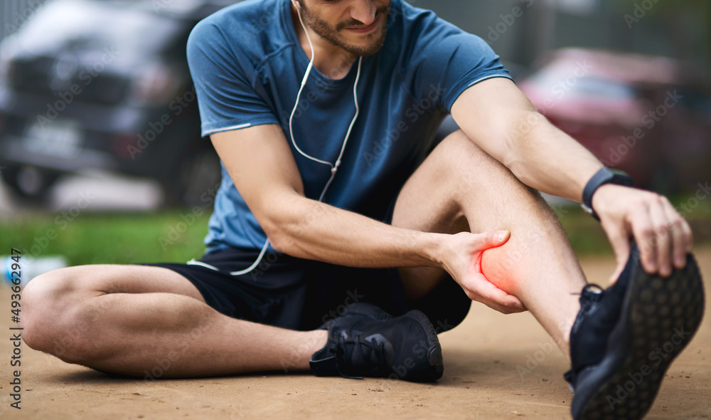 This injury calls for a timeout. Shot of a sporty young man holding his calf in pain while exercising outdoors. This injury calls for a timeout. Shot of a sporty young man holding his calf in pain while exercising outdoors.