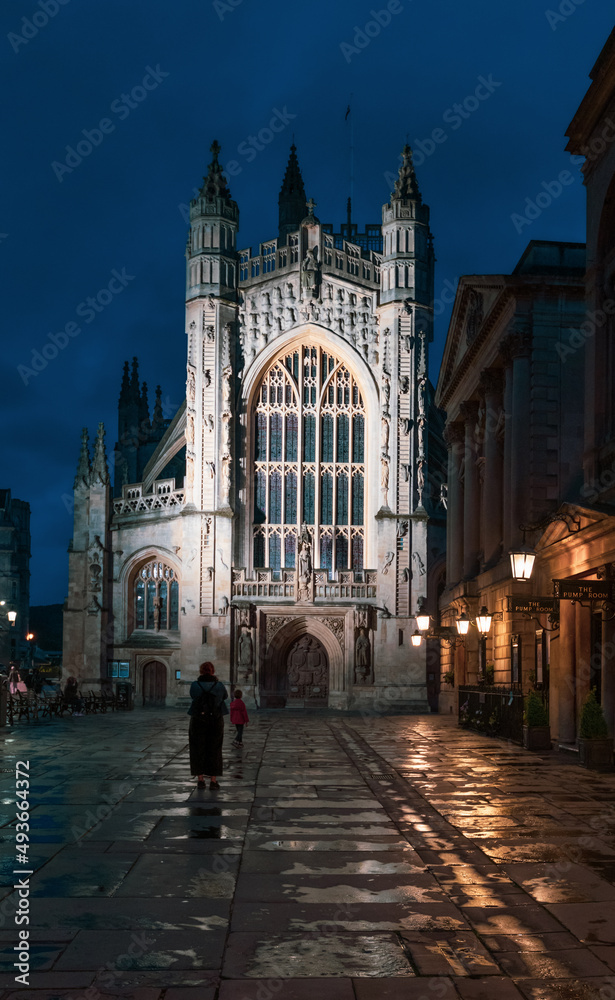 City of Bath, UK. Night sightseeing of Bath downtown with Abbey Church of Saint Peter and Saint Paul next to restored in Victorian times ancient Roman Baths.