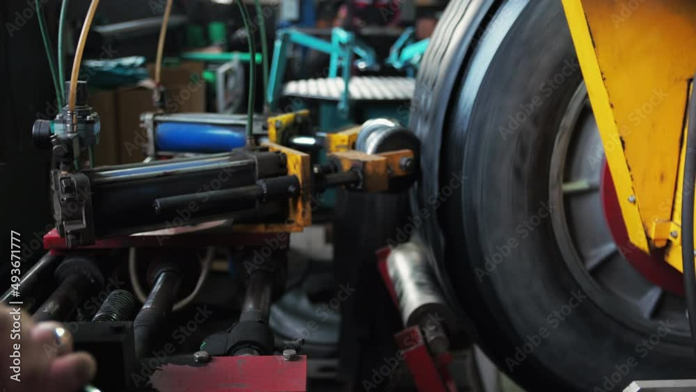 Man repairs a tire from a truck Replaces the coating and glues with a machine finalizes Man repairs a tire from a truck Replaces the coating and glues with a machine finalizes