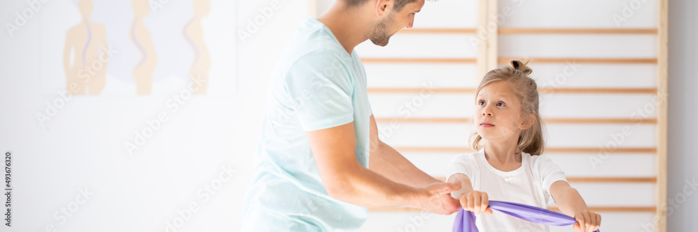 Professional physician explain to child how to perform an exerci Professional physician explain to child how to perform an exerci
