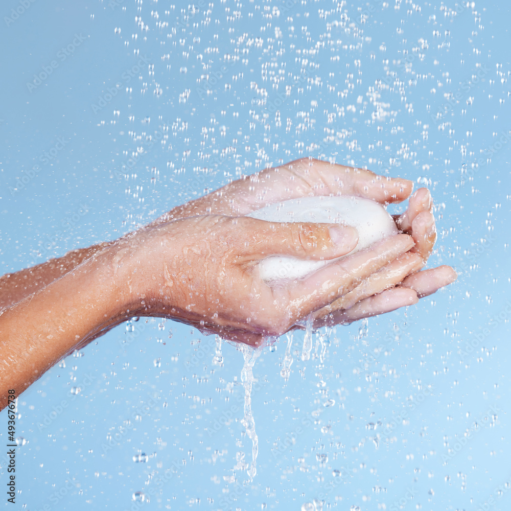 Water and soap are your best friends. Studio shot of an unrecognisable woman holding a bar of soap while taking a shower against a blue background.