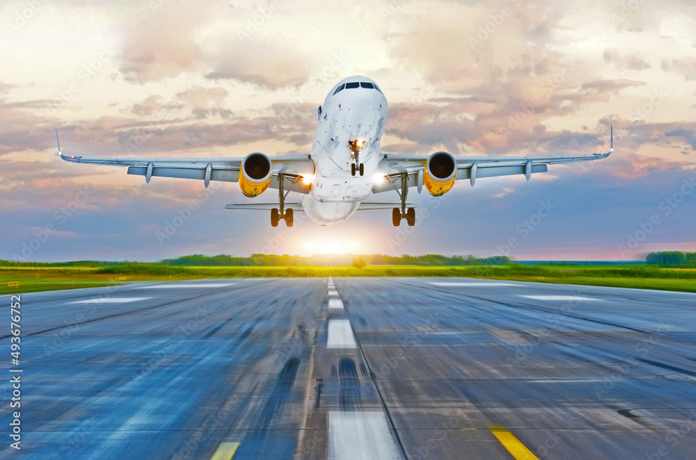 Passenger airplane landing at sunset on a runway. Passenger airplane landing at sunset on a runway.