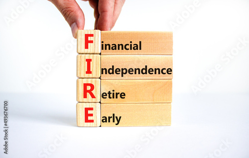 FIRE financial independence retire early symbol. Concept words FIRE financial independence retire early on blocks. White background. Business FIRE financial independence retire early concept. photo