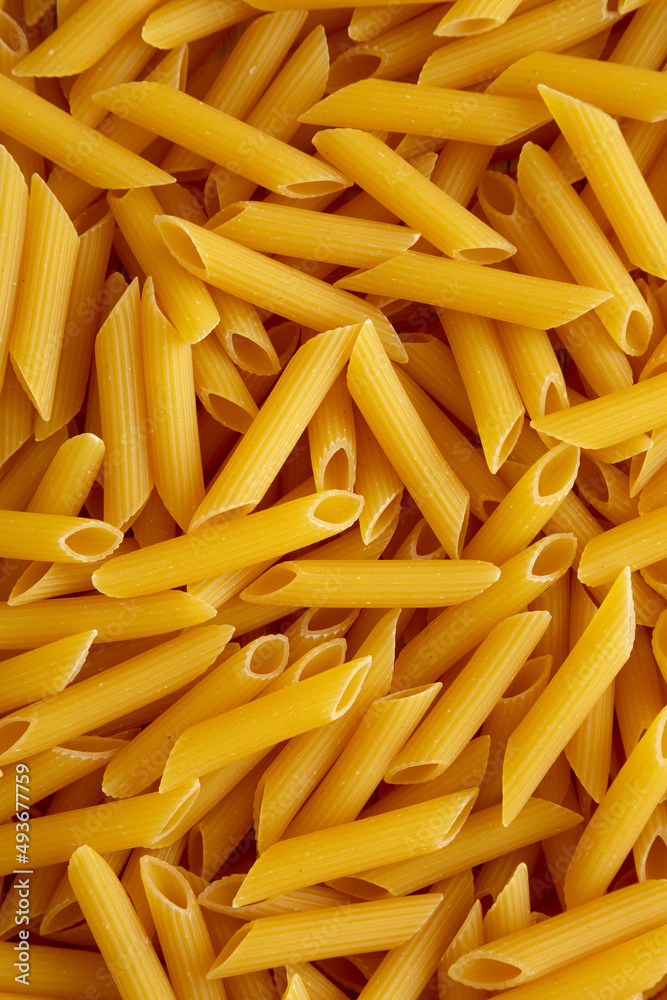 Homemade Raw Dry Penne Pasta, top view. Flat lay, overhead, from above. Homemade Raw Dry Penne Pasta, top view. Flat lay, overhead, from above.