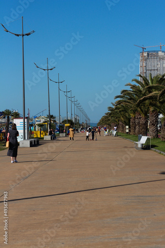Warm sunny spring day on a seaside resort. Promenade walking lane. Batumi, Georgia, March 2022.  © mayflower