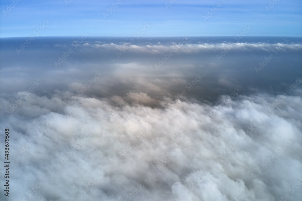 Aerial view from high altitude of earth covered with puffy rainy clouds forming before rainstorm