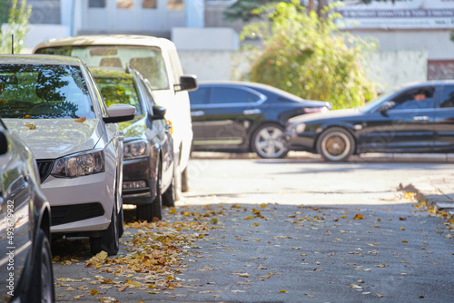 City traffic with many cars parked in line on street side