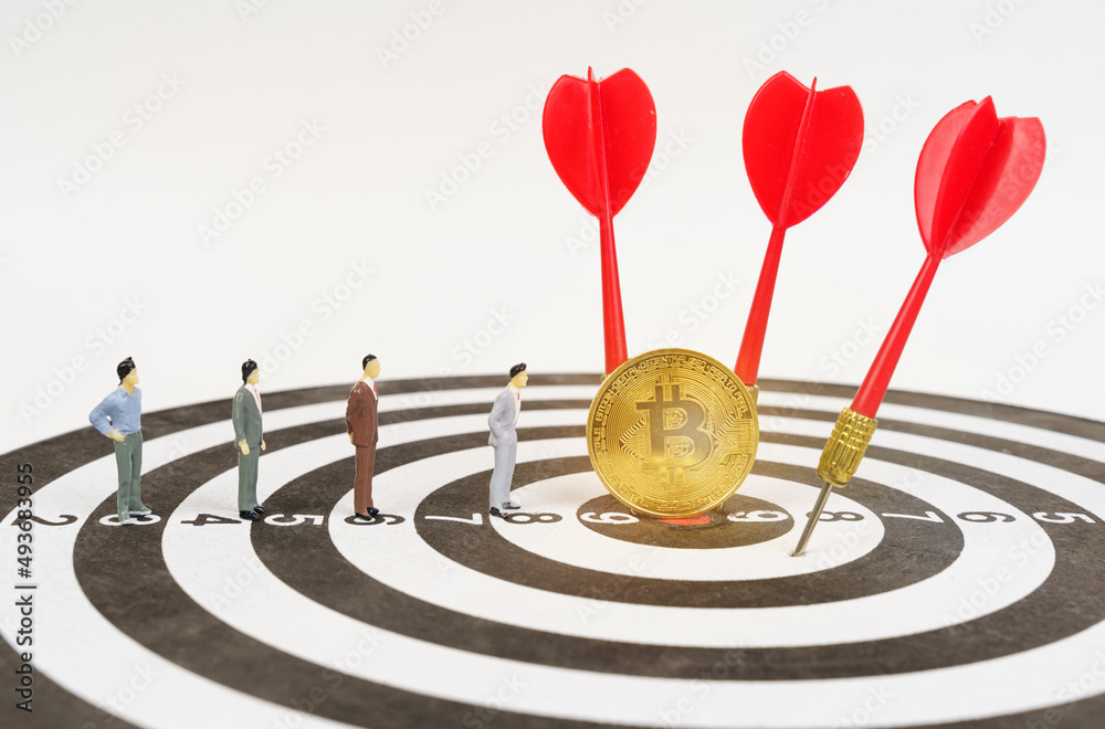 On the target are miniature figures of people, bitcoin, darts. On the target are miniature figures of people, bitcoin, darts.